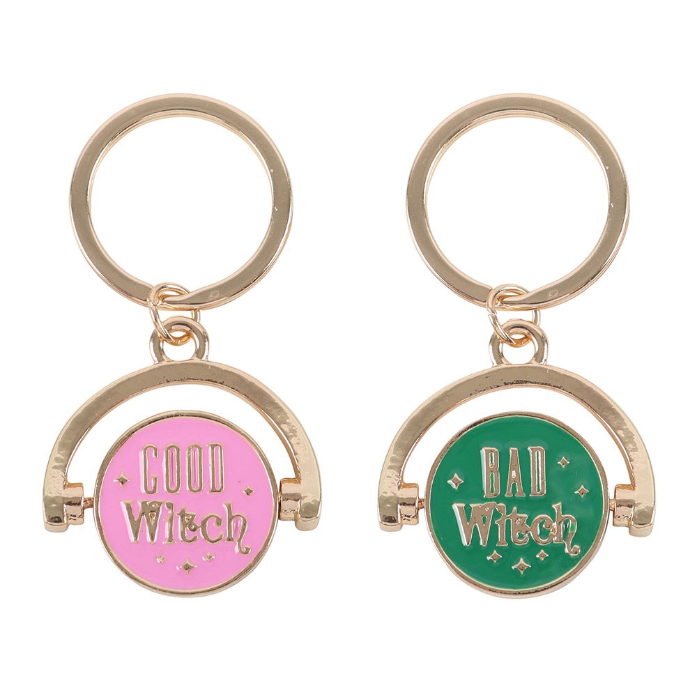 Two keychains with 'Good Witch' and 'Bad Witch' text on pink and green circles, respectively.