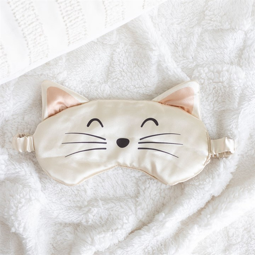 Cat-shaped sleep mask on a soft white surface