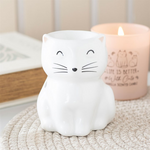 White cat-shaped night light with a candle in the background