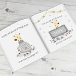 A personalised story book titled 'Big Sister', featuring illustrations of giraffes and a banner with the name 'Amelia' on it, held open by a person.